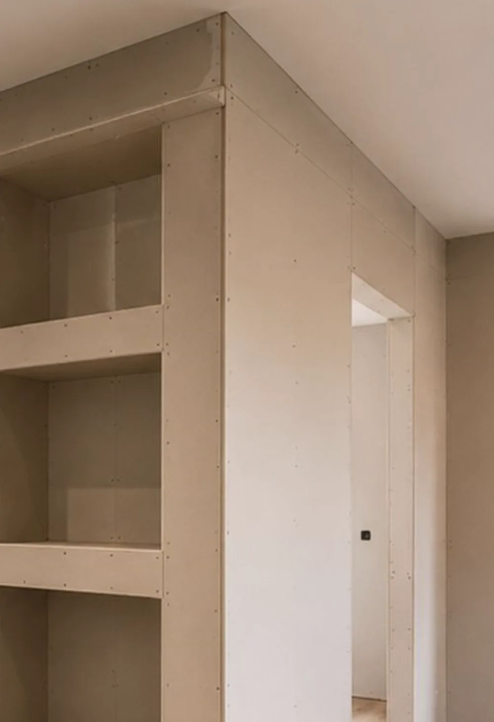 Detalle de tabiquería de pladur con estantería integrada y huecos a medida